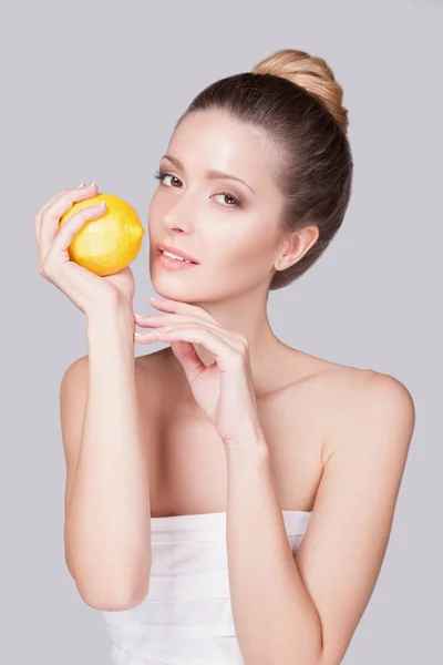 Studio Portrait Playful Young Woman Gathered Hair Lemon Hands Grey — Stock Photo, Image