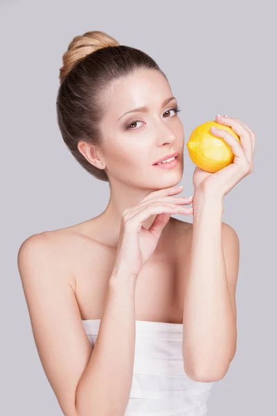 Studio Portrait Playful Young Woman Gathered Hair Lemon Hands Grey — Stock Photo, Image