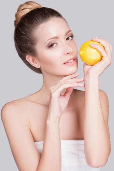 Studio Portrait Playful Young Woman Gathered Hair Lemon Hands Grey — Stock Photo, Image