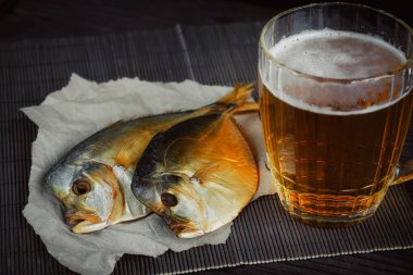 Bira ve koyu ahşap masa üzerinde kurutulmuş balık.