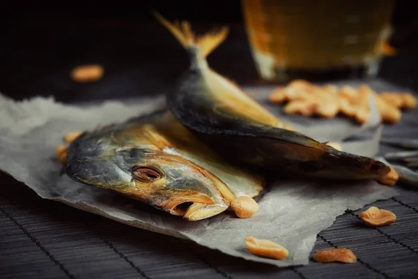 Bere și pește uscat pe masă de lemn întunecat . — Fotografie, imagine de stoc