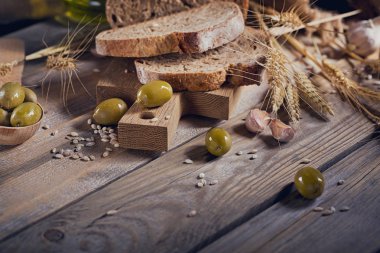 Taze tahıllı ekmek, yeşil zeytin ve buğday kulaklara bir 