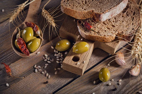 Φρέσκο ψωμί πολύσπορο, ελιές πράσινες, καυτερή πιπεριά και w — Φωτογραφία Αρχείου