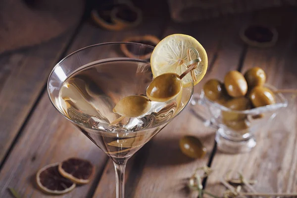 Sklenice martini se zelenými olivami na starý dřevěný stůl — Stock fotografie