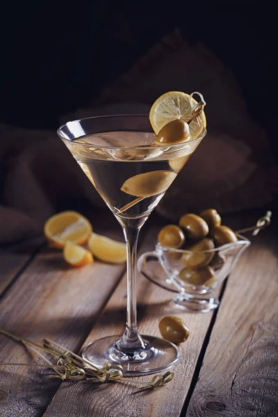 Glas Martini mit grünen Oliven auf einem alten Holztisch — Stockfoto