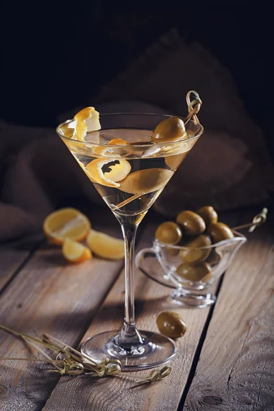 Glas Martini mit grünen Oliven auf einem alten Holztisch — Stockfoto