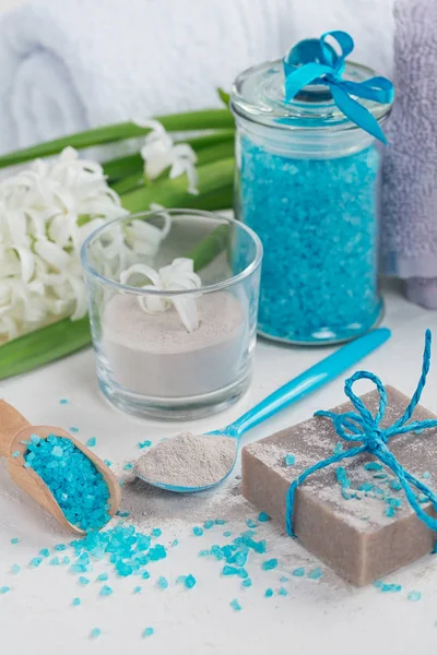 Cosmetic clay powder, homemade clay soap and blue sea salt on wh