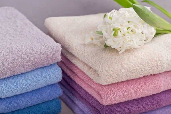 Dos pilas de toallas de baño de colores con flor de jacinto en la luz — Foto de Stock