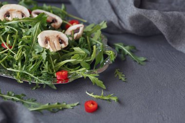 Mantar ve chili biber bir gümüş üzerinde taze yeşil roka 