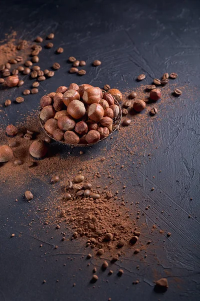 Avellana, granos de café y cacao en polvo en fondo oscuro . —  Fotos de Stock