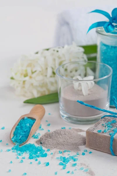 Cosmetic clay powder, homemade clay soap and blue sea salt on wh
