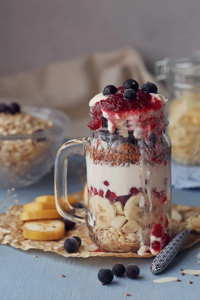 Sobremesa em camadas com muesli, iogurte, banana, sementes de linho, cortadas — Fotografia de Stock