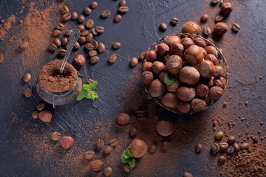 Fındık, kahve çekirdekleri ve koyu arka planda kakao tozu.