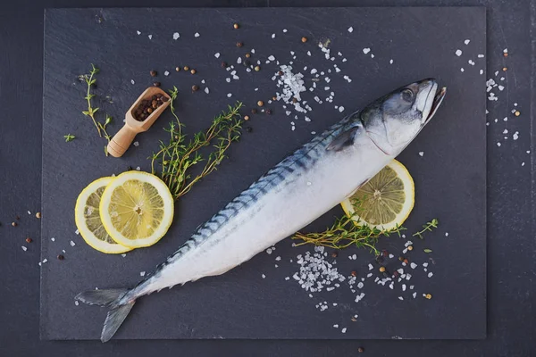 Macrou proaspăt de pește crud și ingrediente pentru gătit pe un ba întunecat — Fotografie, imagine de stoc