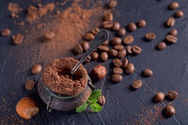 Fındık, kahve çekirdekleri ve koyu arka planda kakao tozu.