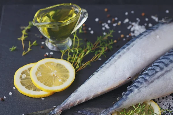 Fresh raw fish mackerel and ingredients for cooking on a dark ba — Stock Photo, Image