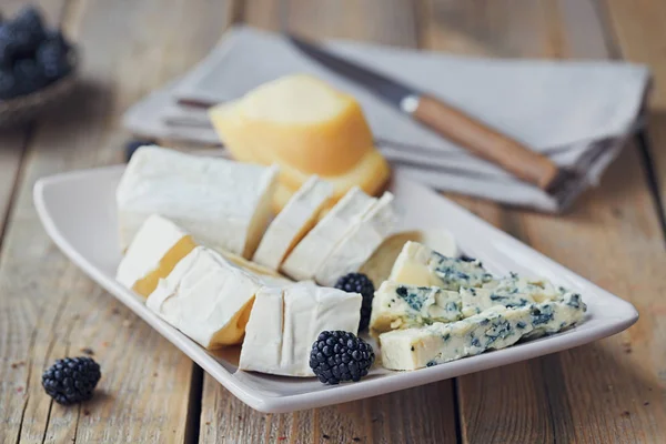 Un plato de queso. Surtido de queso con bayas —  Fotos de Stock