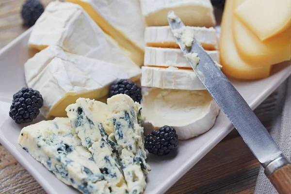Un plato de queso. Surtido de queso con bayas —  Fotos de Stock