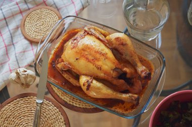 Taze bütün kavrulmuş tavuk pişirme için cam formundaki sarımsaklı