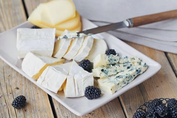 Un plato de queso. Surtido de queso con bayas —  Fotos de Stock