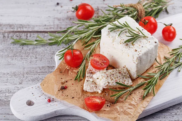 Čerstvý sýr feta sýr s rozmarýnem na bílé Dřevěné Servírovací deska — Stock fotografie