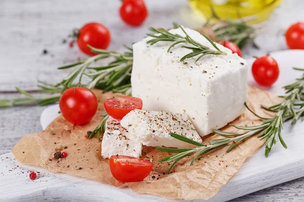 Čerstvý sýr feta sýr s rozmarýnem na bílé Dřevěné Servírovací deska — Stock fotografie