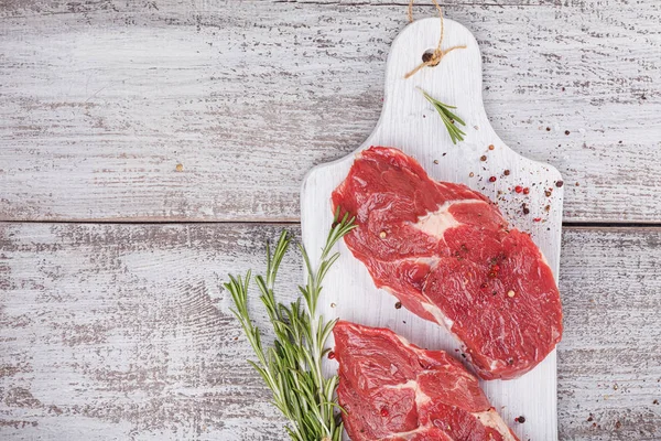 Raw fresh beef steak on a white cutting board