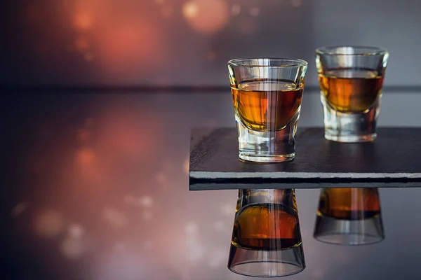 Cognac or liqueur, coffee beans and spices on a glass table. — Stock Photo, Image