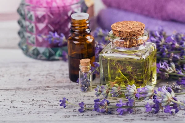 Garrafas de óleo essencial e flores frescas de lavanda — Fotografia de Stock