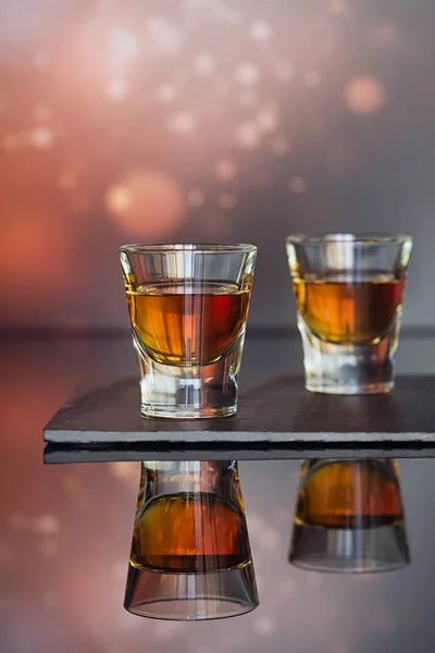 Cognac oder Likör, Kaffeebohnen und Gewürze auf einem Glastisch. — Stockfoto