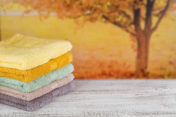 Montón de toallas de baño de colores en tablero de madera clara . — Foto de Stock
