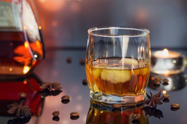 Konyak ya da likör, kahve çekirdekleri ve baharatlar cam masa üzerinde.