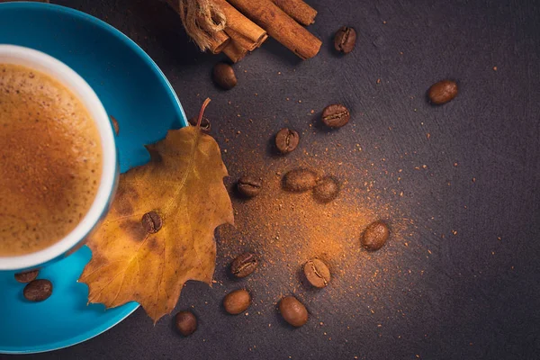 Taza azul de café con granos de café y hojas secas otoñales — Foto de Stock