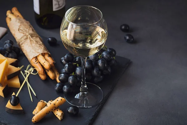 Kaas plaat geserveerd met crackers, druiven en witte win glas — Stockfoto
