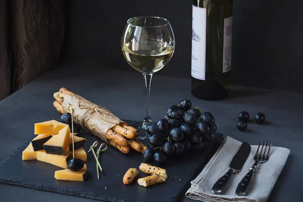 Prato de queijo servido com biscoitos, uvas e vidro de vitória branca — Fotografia de Stock