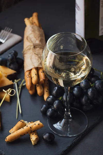 Kaas plaat geserveerd met crackers, druiven en witte win glas — Stockfoto