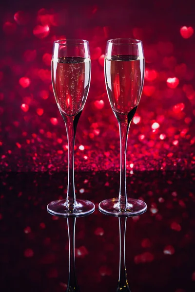 Dos copas de champán con forma de corazón rojo bokeh en el fondo —  Fotos de Stock