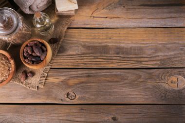 Doğal kozmetik yağı, deniz tuzu ve doğal el yapımı Sabun rustik ahşap zemin üzerine kakao çekirdekleri ile. Sağlıklı cilt bakımı. Spa kavramı. Metin için yer ile Üstten Görünüm.