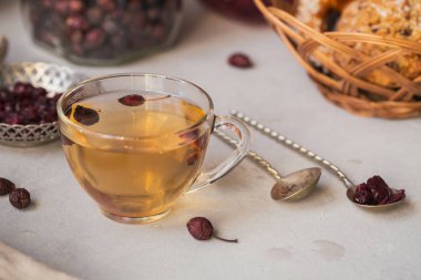 Bir dogrose bir cam fincan sıcak bitkisel çay. Sağlıklı gıda kavramı.