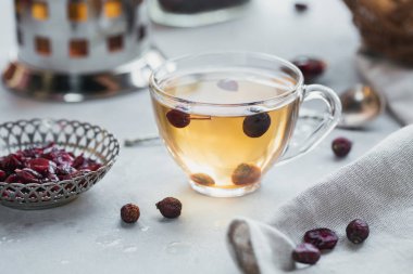 Bir dogrose bir cam fincan sıcak bitkisel çay. Sağlıklı gıda kavramı.