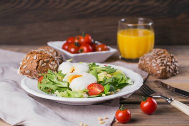 Yeşil salata, domates, kepekli ekmek ve oran ile haşlanmış yumurta