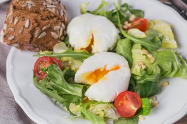 Yeşil salata, domates ve kepekli ekmek ile haşlanmış yumurta