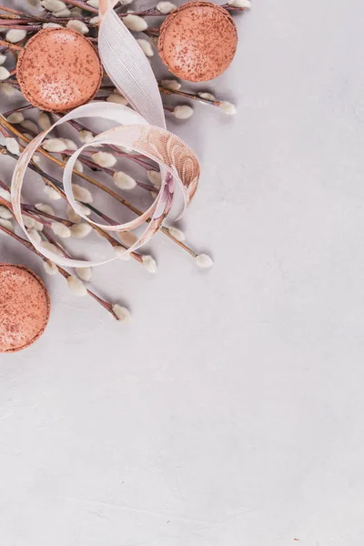 Весенний фон с кучей кисок-ивовых веточек, затянутых ленточкой и сладким шоколадным макароном — стоковое фото