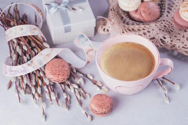 Pink coffee mug with sweet pastel french macaroons, gift box and pussy willow