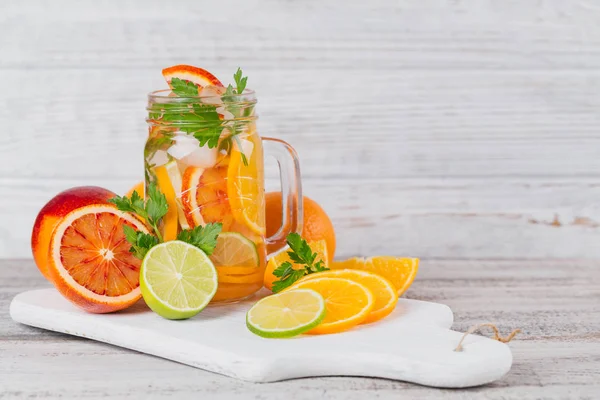 Citrus fruit and herbs water for detox or dieting in glass bottl