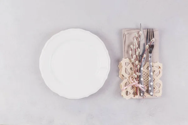 Белая тарелка, столовые приборы, кружевная салфетка и ветки из ивы — стоковое фото