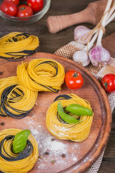 Tomates cherry, espaguetis sin cocer, cebolla roja y hierbas — Foto de Stock