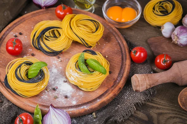 Cherry tomatoes, uncooked spaghetti, red onion and herbs — Stock Photo, Image