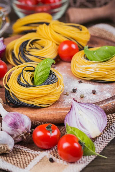 Kirschtomaten, ungekochte Spaghetti, rote Zwiebeln und Kräuter — Stockfoto