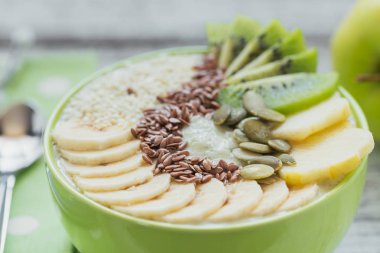 Yeşil smoothie kase kivi, muz, elma ve tohum f ile tepesinde